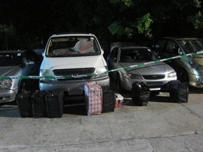 Hong Kong Customs yesterday (July 17) smashed a syndicate using cross-boundary private cars to smuggle illicit cigarettes. Photo shows bags containing the illicit cigarettes and the private cars seized in the operation.