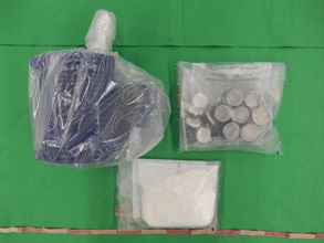 香港海关昨日（九月十八日）在香港国际机场检获约一点一公斤怀疑可卡因，估计市值约一百六十万元。图示检获的怀疑可卡因及用作收藏毒品的金属部件。