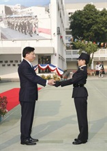 The Secretary for Financial Services and the Treasury, Professor K C Chan, presenting a "Whistle of Honour" to one of the best recruits, Customs Officer Cheung Ying-suet at the Customs passing-out parade today (December 7).
