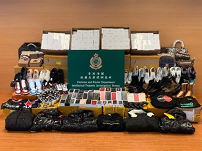 Hong Kong Customs conducted a three-week joint operation with the Mainland and Macao Customs from November 23 to yesterday (December 13) to combat cross-boundary counterfeiting activities among the three places and with goods destined for overseas countries. During the operation, Hong Kong Customs seized about 18 000 items of suspected counterfeit goods with an estimated market value of about $2.3 million. Photo shows some of the suspected counterfeit goods seized, including mobile phones and accessories, clothes and footwear.