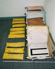 行李箱的暗格及案件中检获的毒品。
