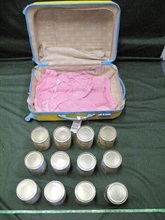 The suspected cocaine concealed in the canned fruit inside the checked-in suitcase.