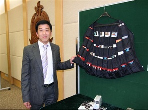 Deputy Head of the Revenue and General Investigation Bureau, Customs and Excise Department, Mr Kong Shui-wing shows a vest with illicit cigarettes concealed inside.