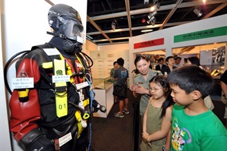 海关人员向两位参观展览的小朋友讲解海关潜水队的装备。