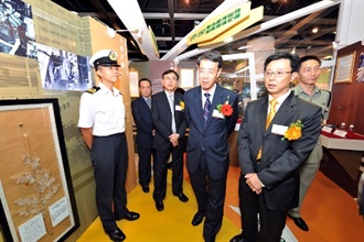 Commissioner of Customs and Excise, Mr Richard Yuen (third from right), strolls through the 'time tunnel' to review the historical development of the department. Accompanying him is the Deputy Commissioner, Mr Luke Au Yeung (second from right).