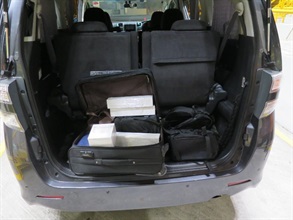 部分检获的智能手表及智能手机藏于车尾行李箱内。