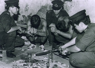 香港海关百周年回顾展览其中一张历史图片－－缉私人员捣破一个鸦片烟格 (一九五○年代图片)。