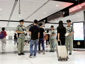 海关人员于暑假期间在边境管制站派发传单，提醒旅客切勿携带禁运或受管制物品进出香港。