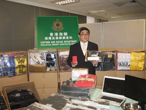 海关版权调查组指挥官关煜群在记者会上展示所检获的冒牌货品。