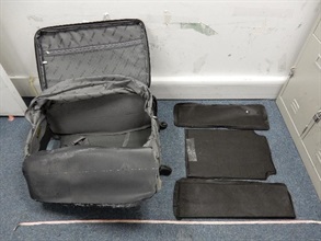 香港海关昨日（九月三十日）在香港国际机场检获怀疑可卡因。图示海关人员在行李箱暗格内发现的三块怀疑可卡因。