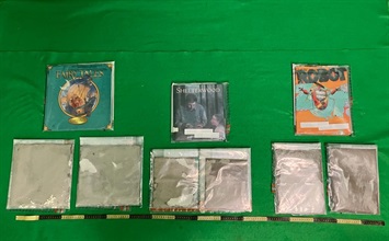 香港海關八月十一日在香港國際機場檢獲約兩公斤懷疑可卡因，估計市值約二百一十萬元。圖示檢獲的懷疑可卡因及用作收藏毒品的書本。