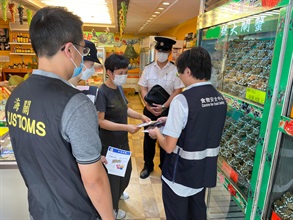Hong Kong Customs and the Centre for Food Safety and the Environmental Hygiene Branch of the Food and Environmental Hygiene Department (FEHD) have been carrying out joint enforcement operations since last Friday (September 15) to inspect hairy crab retail outlets in various districts, with the aim of protecting consumer rights and upholding food safety by ensuring hairy crabs on sale in the market comply with relevant stipulations and requirements under the laws. Photo shows Customs officers and FEHD officers inspecting a retail shop selling hairy crabs and distributing relevant promotional leaflets.