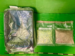 香港海關今日（一月七日）在香港國際機場偵破一宗旅客以行李藏毒的販毒案件，檢獲約五點二公斤懷疑搖頭丸，估計市值約七十萬元。圖示檢獲的懷疑搖頭丸及用作收藏毒品的寄艙行李。