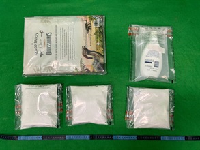 香港海關昨日（一月九日）在香港國際機場偵破一宗旅客以行李藏毒的販毒案件，檢獲約一公斤懷疑可卡因，估計市值約一百萬元。圖示檢獲的懷疑可卡因及用作收藏毒品的書籍和膠瓶。