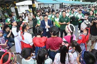 保安局局长邓炳强（中）今日（四月十四日）参观香港海关学院开放日，与穿着国家不同民族服饰的小学生交谈。