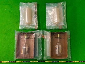 香港海關二月二十五日在香港國際機場檢獲約一點七公斤懷疑液態可卡因，估計市值約二百六十萬元，並於昨日（三月三日）拘捕一名男子。圖示檢獲的懷疑液態可卡因及用作收藏毒品的兩個糖漿瓶。