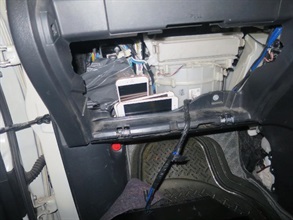 海關於私家車前座乘客位置前方的工具箱內發現的智能電話。
