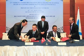 The Commissioner of Customs and Excise, Mr Roy Tang (second left), and the Director General of the Royal Malaysian Customs Department, Dato' Sri Khazali bin Haji Ahmad (second right), witnessed by the World Customs Organization Secretary General, Mr Kunio Mikuriya (centre), sign a Mutual Recognition Arrangement document in Kuala Lumpur, Malaysia, today (March 17) to mutually recognise the Authorized Economic Operator Programmes of Hong Kong and Malaysia.