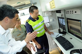 Mr Leung is briefed by Customs officers on the operation of the mobile x-ray vehicle scanning system to detect contraband at Kwai Chung Customhouse.