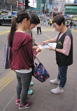 A Customs officer distributes pamphlets to visitors in Mong Kok.