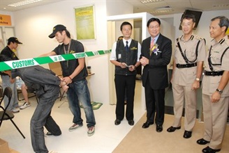 The Secretary for Commerce and Economic Development, Mr Frederick Ma (third right), watching a raid demonstration on a domestic pirated optical disc copying workshop after opening the IPR Enforcement Museum today (October 30).<br />He is accompanied by Commissioner of Customs and Excise, Mr Richard Yuen (second right), and Assistant Commissioner, Mr Tam Yiu-keung (first right).