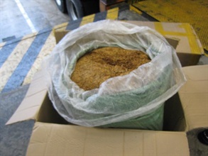 Seized illicit tobacco was packed in green nylon bags and concealed in paper boxes.