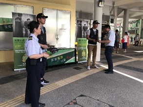 Hong Kong Customs today (July 11) started a campaign to step up publicity at public housing estates all over Hong Kong to spread anti-illicit cigarette messages to members of the public. Jointly organised with the Housing Department, the campaign will last until July 18. Photo shows Customs officers distributing leaflets to passers-by.