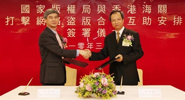 The Assistant Commissioner of Customs and Excise Department, Mr Tam Yiu-keung (right), exchanges documents with the Director General of the Copyright Division, National Copyright Administration of the People's Republic of China, Mr Wang Ziqiang, after signing the co-operation agreement.
