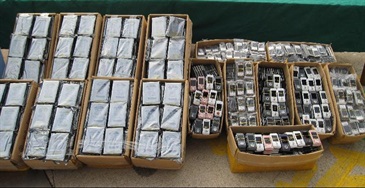 Some of the seized computer hard disks and mobile phones.