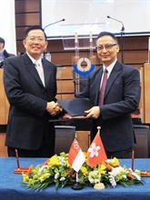 Mr Cheung (right) and Mr Ho (left) exchange the MRA document.