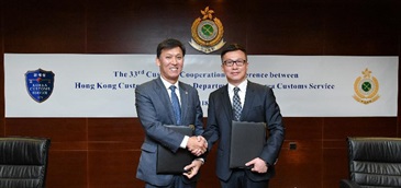 香港海關關長鄧以海（右）和韓國關稅廳廳長金榮文（左）今日（四月十日）簽訂中國－－韓國自由貿易協定有關原產地管理的合作及互助備忘錄後交換文件。