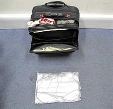 A pack of cocaine concealed inside the false compartment of the bag.