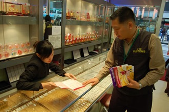 A Customs officer distributes publicity leaflets to a shop to get retailers familiar with the new provisions under the Trade Descriptions Ordinance, which will come into effect on March 2.
