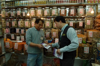 A Customs officer distributes publicity leaflets to a shop to get retailers familiar with the new provisions under the Trade Descriptions Ordinance, which will come into effect on March 2.