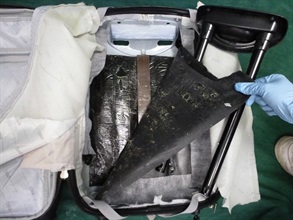 The suspected cocaine concealed in the false compartment of the suitcase.