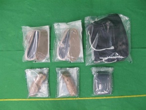 香港海關昨日（十二月二十三日）在香港國際機場檢獲約二點一公斤懷疑可卡因，估計市值約二百四十萬元。圖示檢獲的懷疑可卡因，以及被捕女子的鞋及手提行李袋。