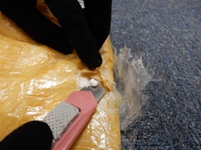The suspected cocaine concealed inside the false compartment of the suitcase.