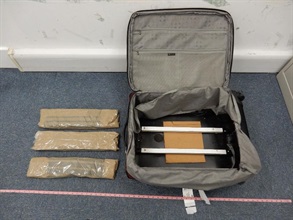 Suspected cocaine in three slabs concealed in the false compartment of the check-in suitcase.