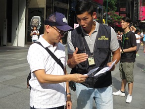 Customs officers distribute pamphlets to members of the public in Tsim Sha Tsui, Kowloon.