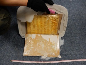 A slab of suspected cocaine concealed inside the false compartment of the suitcase.