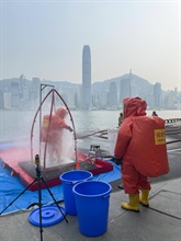 香港海关及消防处今日（五月三十日）下午在海运码头联合举行代号「把关者II」的反恐演习。图示穿着化学物品保护袍的消防处人员于现场进行技术洗消。