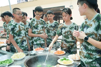 The Commissioner of Customs and Excise, Ms Louise Ho, today (August 13) officiated at the graduation ceremony of the Military Training Experience Camp for Hundred Youths organised by "Customs YES" in Shenzhen. Photo shows participants having outdoor cooking experience to develop self-discipline and team spirit building.