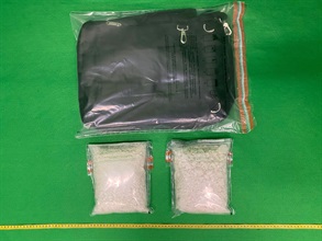 香港海關昨日（十月十三日）在香港國際機場破獲一宗旅客販運毒品的案件，檢獲約兩公斤懷疑可卡因，估計市值約二百二十萬元。圖示檢獲的懷疑可卡因及用作收藏毒品的手提行李袋。