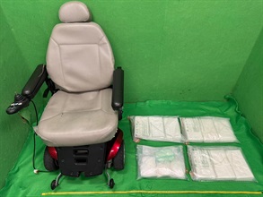 香港海關昨日（十月十四日）在香港國際機場偵破一宗旅客販運毒品的案件，檢獲約十一公斤懷疑可卡因，估計市值約一千二百萬元。圖示檢獲的懷疑可卡因和用作收藏毒品的電動輪椅。