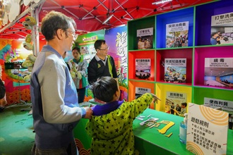 The Customs and Excise Department has set up a Lunar New Year (LNY) fair stall with the theme "Customs' Festive Dragon Vibe" and organised a charity sale in partnership with the social service organisation, Suicide Prevention Services, at the Victoria Park LNY Fair from February 7 to 9. Photo shows members of the public participating in the stall games.