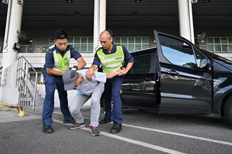 Hong Kong Customs and the Fire Services Department co-organised a counter-terrorism intelligence and hazardous material incident exercise codenamed "WOLFHUNT" this afternoon (June 24) at the Shenzhen Bay Control Point. Photo shows Customs officers subduing a light goods vehicle driver who was suspected to be involved in terrorist activities.