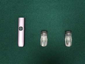 A 42-year-old incoming male passenger was convicted by the Fanling Magistrates' Courts today (September 15) for possession of a dangerous drug and possession of apparatus fit and intended for the smoking of a dangerous drug, in contravention of the Dangerous Drugs Ordinance. He was sentenced to two months' imprisonment for each of the charges that will run concurrently. Photo shows the etomidate capsules and e-cigarette device seized.