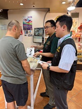 Hong Kong Customs conducted patrols during the Mainland's National Day Golden Week period at popular shopping spots in various districts and reminded traders to comply with the requirements of the Trade Descriptions Ordinance, with a view to safeguarding the rights of local consumers and visitors. Photo shows Customs officers distributing pamphlets in Tsim Sha Tsui.