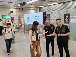 Hong Kong Customs conducted patrols during the Mainland's National Day Golden Week period at popular shopping spots in various districts and reminded traders to comply with the requirements of the Trade Descriptions Ordinance, with a view to safeguarding the rights of local consumers and visitors. Photo shows Customs officers distributing pamphlets at the Shenzhen Bay Control Point.