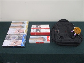 一名四十八歲抵港女旅客因管有未完稅香煙和未有向海關人員作出申報，違反《應課稅品條例》，今日（十二月十二日）在粉嶺裁判法院被判處監禁四星期及罰款八百元。圖示檢獲的未完稅香煙和用作收藏未完稅香煙的背包。